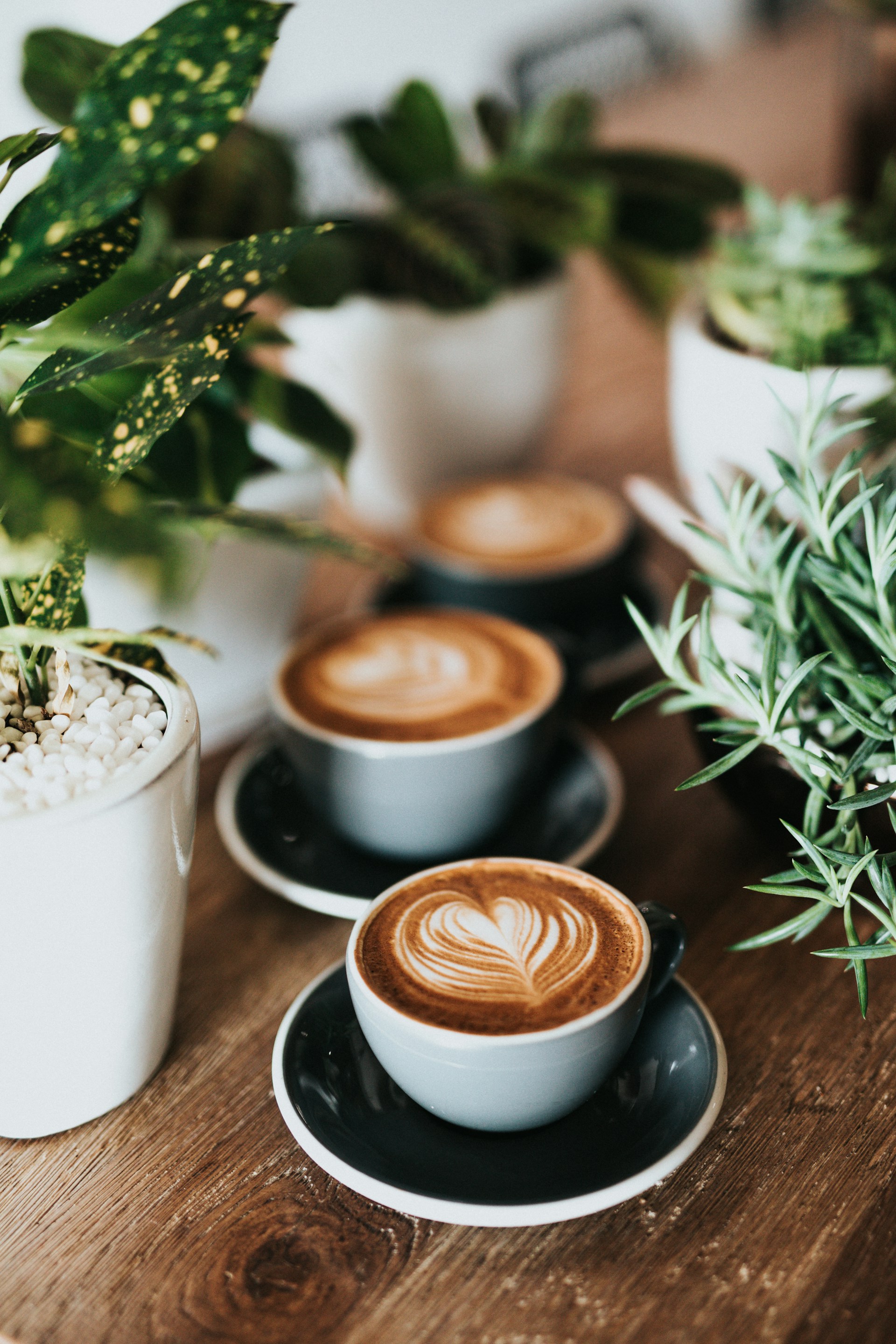 Coffee cup beside a printed weekly calendar on a graphite desk